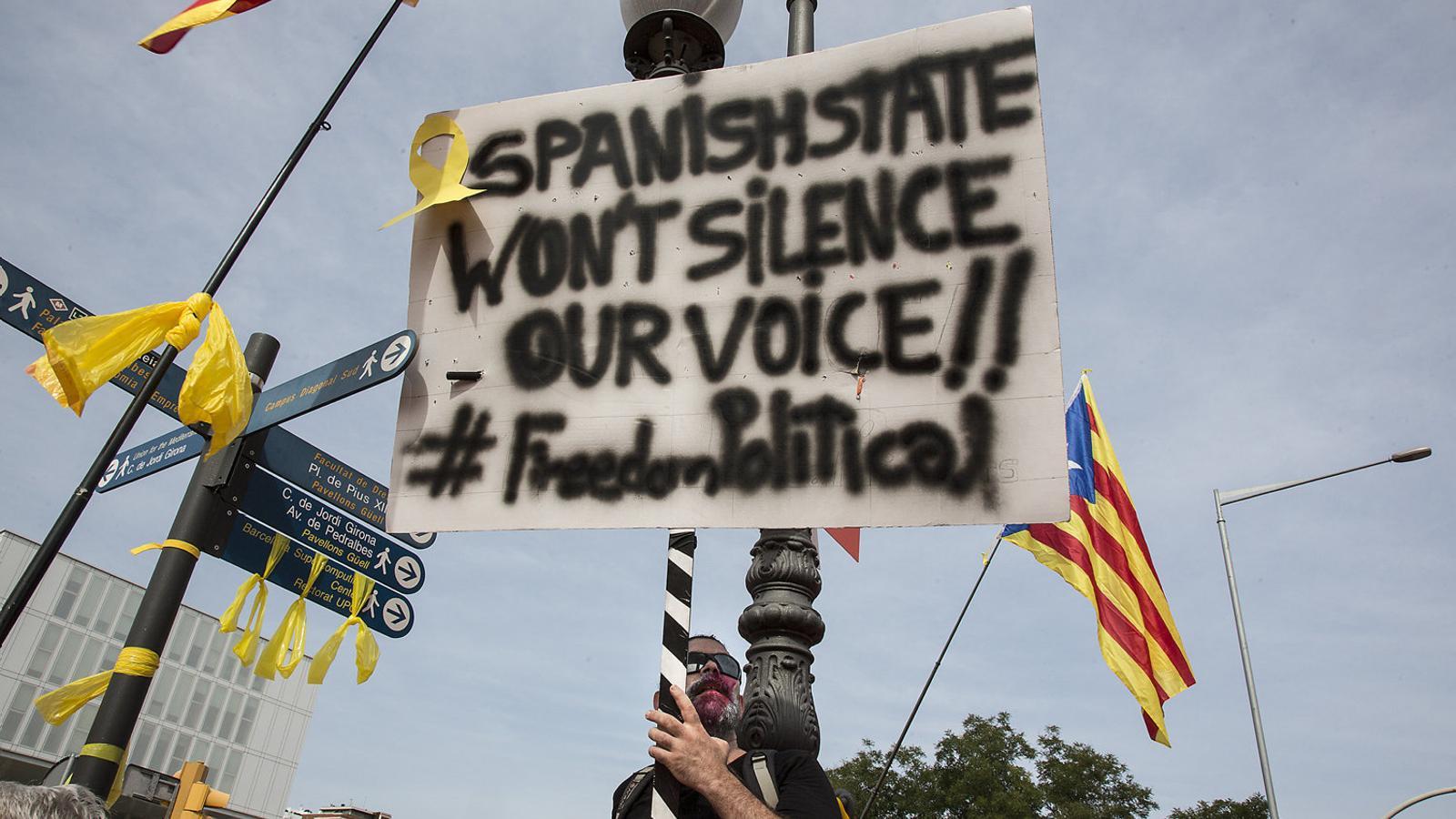 Participant dâ€™una manifestaciÃ³ independentista a Barcelona amb un cartell per la llibertat dels presos en anglÃ¨s. / CRISTINA CALDERER