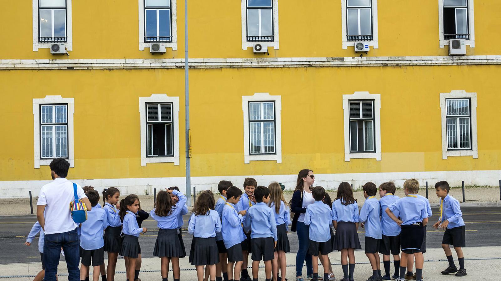 Alumnes d’un centre públic fent cua en un carrer del centre de Lisboa en una sortida escolar. / JEFF GREENBERG / GETTY