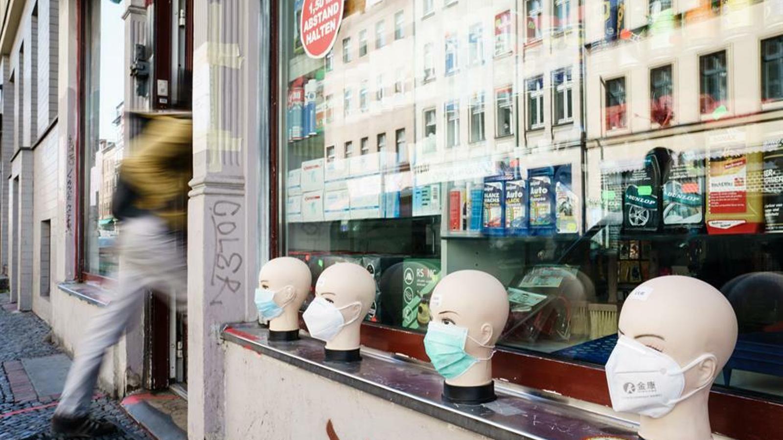 Mascaretes de protecció en venda a l'aparador exterior d'una botiga de Berlín / CLEMENS BILAN / EFE